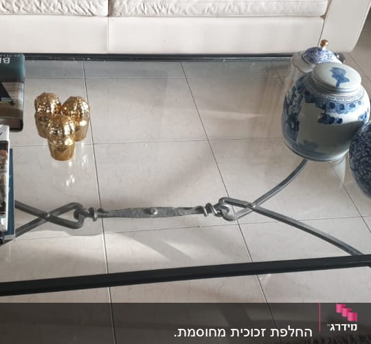 שולחן זכוכית עם ספרים וקישוטים עליו